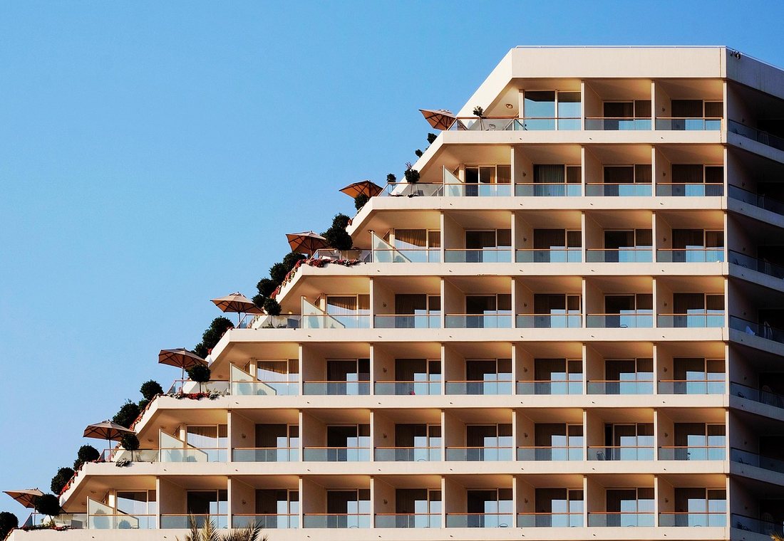 The Horizon Quay building in daylight, balconies stepped above the water